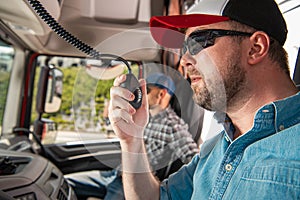 Young Truck Driver Calling Fellow Drivers Using CB Radio