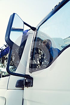 Young truck driver gets out of the truck.