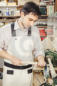 Young turner engages in wood carving on lathe for wood