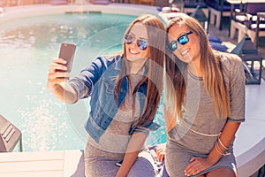 Young two girls laughing and taking selfie