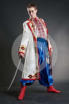 Young ukrainian cossack posing with sabre