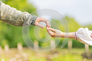 Young ukrainian couple in embroidered national shirts holding hands. Man and woman ouydoor. Lovers, family, trust, love