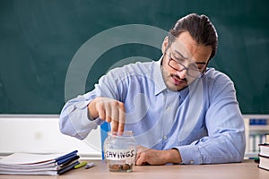 Young underpaid male teacher in the classroom photo