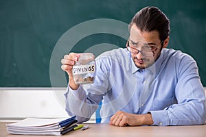 Young underpaid male teacher in the classroom photo