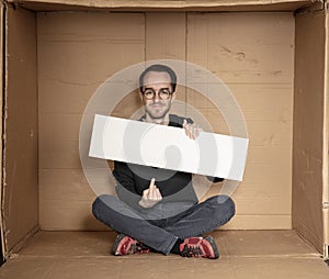 Young unemployed man holding a white board, a place for advertising, the idea of a cry for help