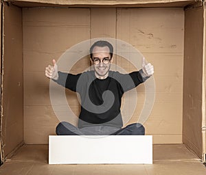 Young unemployed man holding a white board, a place for advertising, the idea of a cry for help