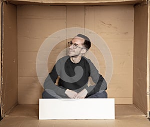 Young unemployed man holding a white board, a place for advertising, the idea of a cry for help