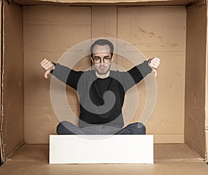 Young unemployed man holding a white board, a place for advertising, the idea of a cry for help