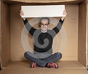 Young unemployed man holding a white board, a place for advertising, the idea of a cry for help