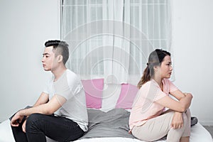 Young Unhappy Asian Couple Sitting Back To Back On Sofa At Home