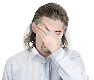 Young unhappy guy covers eye with hand isolated