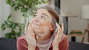 Young unhappy stressed woman sitting at home covering her ears with hands because of the loud noise coming from