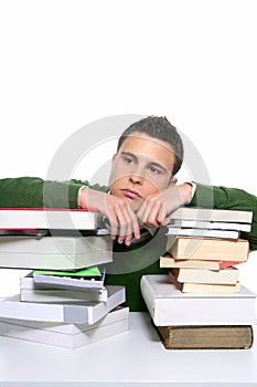 Young unhappy student with stacked books