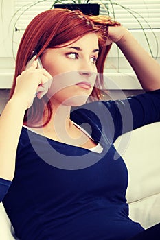 Young unhappy and upset woman talking by phone