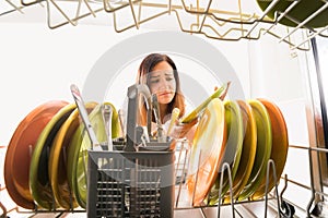 Woman Looking At Plate Near Dishwasher photo