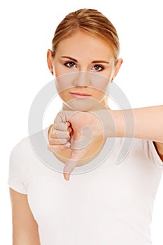 Young unhappy woman showing thumb down