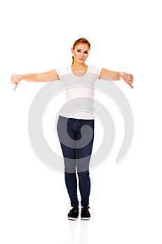 Young unhappy woman showing thumbs down.