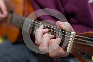 Young unidentifiable musician playing on the guitar