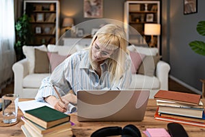 Young university student, college woman or girl, study for final exam at home. Young female learning and educate herself using