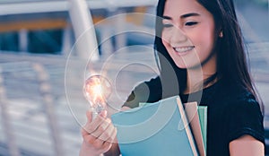 Young university student holding light bulb,creative idea