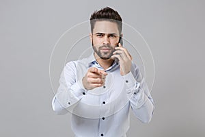 Young unshaven business man in light shirt isolated on grey wall background. Achievement career wealth business concept