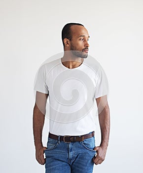 A young unshaven man on a light gray background. Mixed race handsome male model.