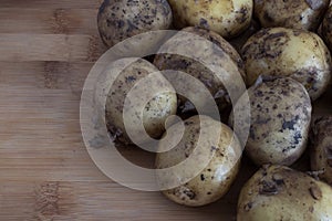 Young untreated potatoes close-up on a wooden backgroundb autumn harvest