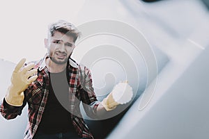 Young Upset Man Cleaning White Toilet at Home.