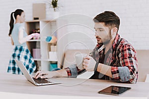 Young Upset Woman Cleaning Room with Lazy Man.