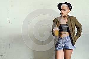 Young urban girl in short shorts holding drink