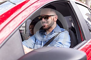 Young professional driver taking passenger to ride in private vehicle. Concept of commute, transport service, mobility.