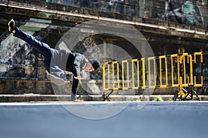 Young urban street dancer or bboy freezes showing off some moves on street in city