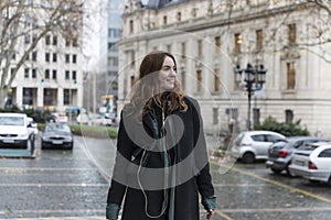 Young Urbanite Woman with Genuine Smile Looking Away in City photo