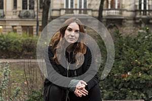 Young Urbanite Woman Looking at Camera Seated on Bench photo