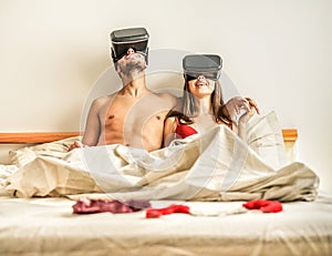 Young using virtual reality glasses for sex in bedroom - Two lovers using new vr technology for intimate moments - New tech trends