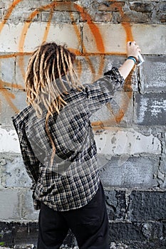 Young vandal drawing graffiti