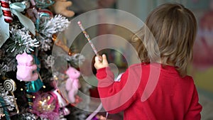 Young very attractive girl is playing. In background there is christmas tree.