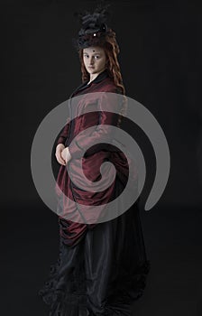 A young Victorian woman in a dark red and black ensemble photo