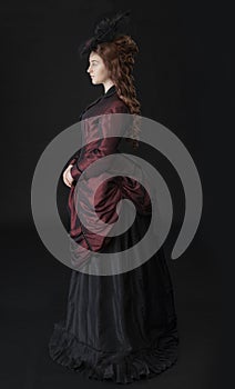 A young Victorian woman in a dark red and black ensemble photo