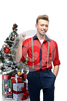 Young vintage man standing near christmas tree