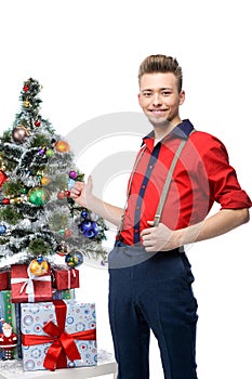 Young vintage man standing near christmas tree