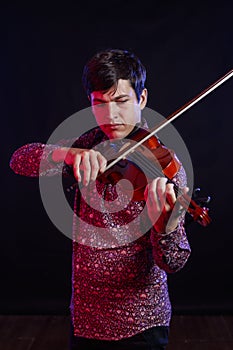 Young violinist playing. Concept of music, hobby, art, lifestyle. Musician isolated. Black background