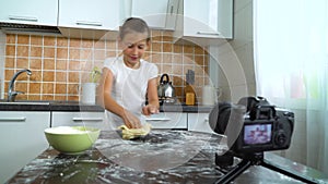 Young vlogger recording video content for food blog kneading dough