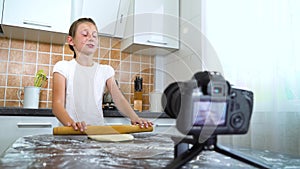 Young vlogger recording video content for food blog rolling dough with rolling pin