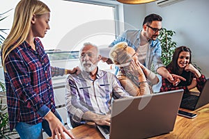 Young volunteers help senior people on the computer