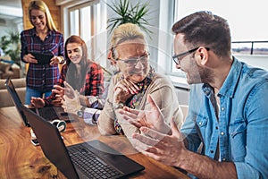 Young volunteers help senior people on the computer