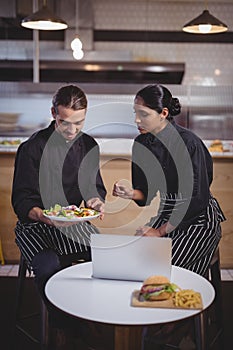 Young wait staff discussing over food while sitting at coffee shop