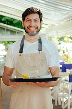 Young waiter holding tray