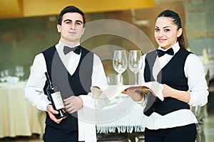 Young waiter and waitress at service in restaurant