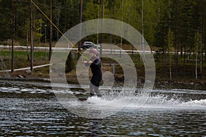 Young wakeboarder rides a wakeboard on the lake. Wakeboarding is cool, extreme sport